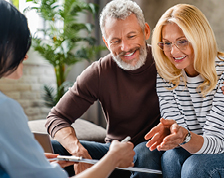 Middle aged couple reviews their policy with an insurance agent